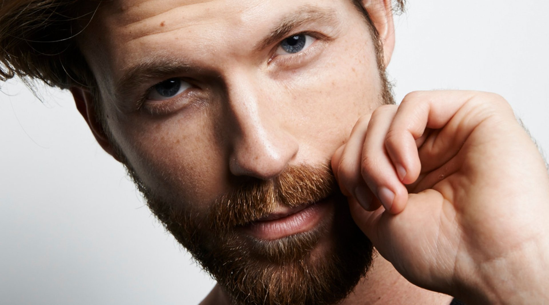 Mann im Seitenprofil lächelt, 5-Tage-Bart ist im Fokus